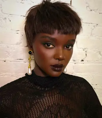 model wears deep berry toned lipstick and dark eyeshadow 