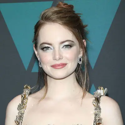Emma Stone wears silver and gold eyeshadow, dewy blush, and pink lipstick