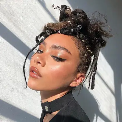 Hailey Long with neutral eyeshadow, green eyes, winged eyeliner, dewy skin, and neutral pink lipstick