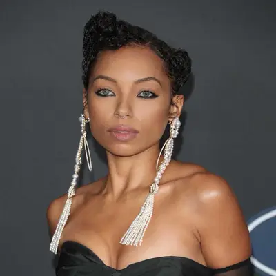 Logan Browning with dramatic black lower lash line eyeliner, neutral eyeshadow, green eyes, and asymmetrical updo hairstyle