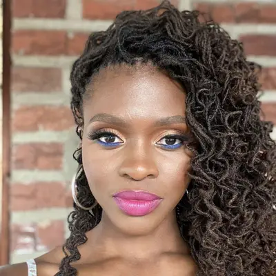 woman with curly hair and smokey blue eye liner