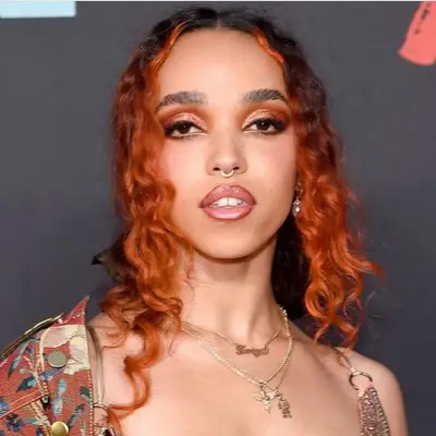 FKA Twigs in rusty colored eyeshadow and fiery red hair.