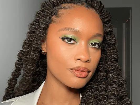 Makeup artist Khera Alexander wearing a green eyeshadow look.