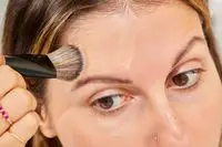 A person applies foundation to their forehead using a Sephora Collection PRO Foundation Brush #47