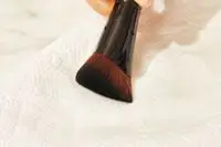Close-up of a Laura Mercier Real Flawless Foundation Brush on a paper towel