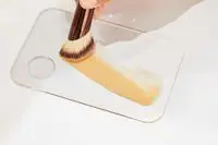 A Hourglass Ambient Soft Glow Foundation Brush drags makeup