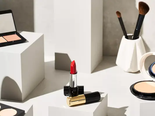 Lipstick, a powder compact, makeup brushes, and other makeup palettes