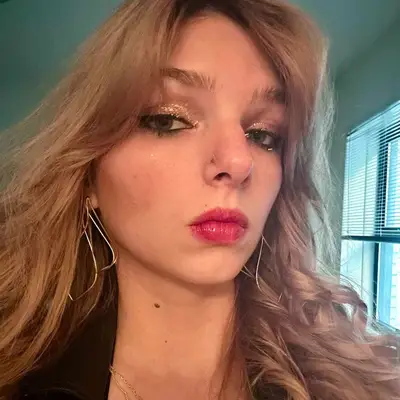 Ali Webb with a glossy red lip and shimmering eyeshadow