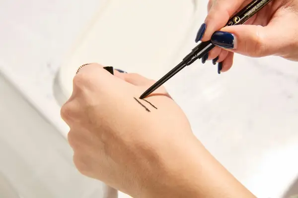 Person tests Hourglass Voyeur Waterproof Gel Eyeliner on their hand