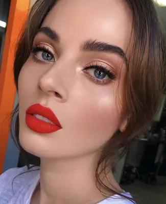 model wears shimmery copper shadow with bold red matte lipstick 