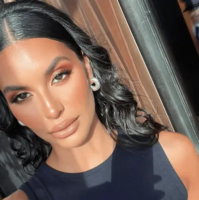 Kela Walker wears copper eyeshadow with black eyeliner, nude lips and a sparkling champagne color dress