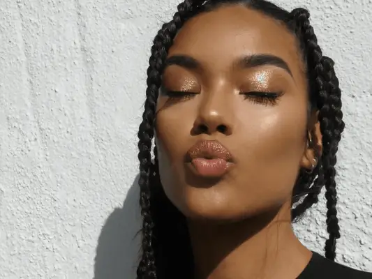 Model with brown braids and copper shimmer eyeshadow