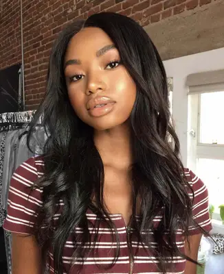 model has a natural, glowing complexion with highlighted cheekbones, nude glossy lips and natural eyeshadow