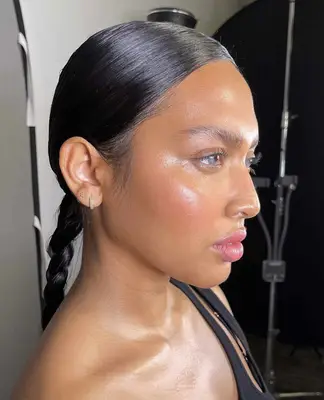 model wears glossy makeup on the eyes, cheeks and lips with pink lipstick and blush