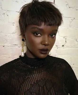 model is wearing soft black shadow around the eyes and blackberry toned lipstick