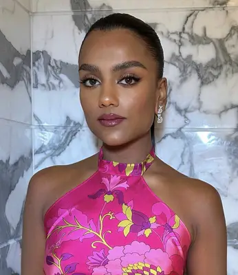 model wears black liquid eyeliner on lids with fuschia pink lipstick and a natural complexion