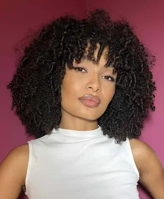 Yara Shahidi wears soft makeup with glossy lips and liquid eyeliner on the eyes in a thin winged out shape