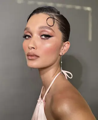 model wears rose gold eyeshadow with liquid liner, pink blush and nude lipstick 