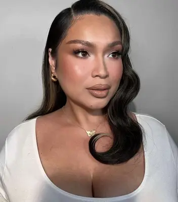 Model wears natural nude tones on the eyes cheels and lips with shaped eyebrows