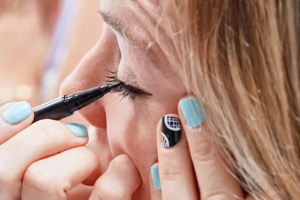 Person applying KVD Beauty Tattoo Liner Vegan Waterproof Liquid Eyeliner to their waterline