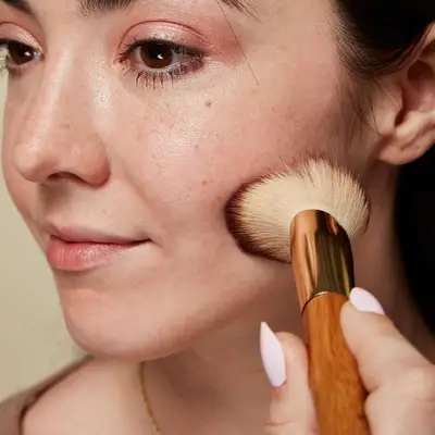 Woman adds powder to her cheek