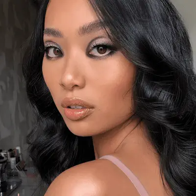Model with long wavy hair and dark eyeshadow creases