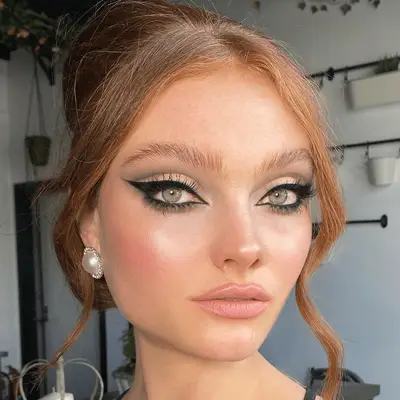 Model with red hair in an updo with soft smokey eye makeup