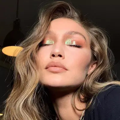 Gigi Hadid wears a peach and iridescent green shimmery eye makeup look