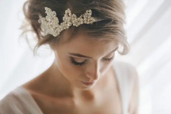 Bride with long lashes and a pearl headband