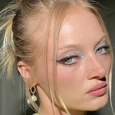 Black winged liner with silver glitter shadow in the inner corner.