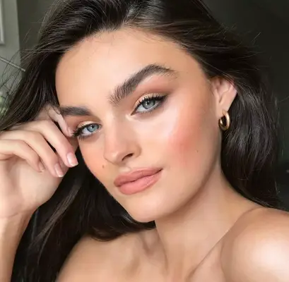 model is wearing a natural makeup and eyeshadow look with tightliner and soft pink lips