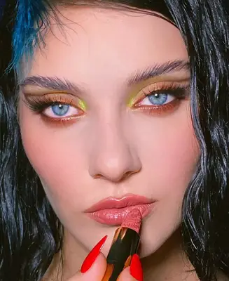 model poses wearing copper and light neon yellow eyeshadow