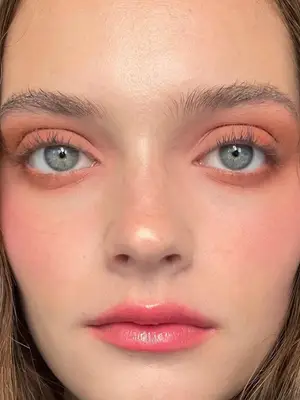 model wearing peach eyeshadow and pink gloss