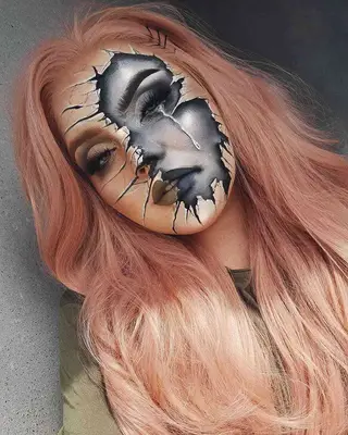 Makeup artist wears broken glass-inspired look with cracks and teary eye