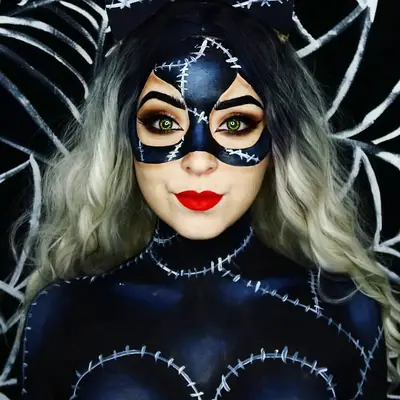 Makeup artist with Catwoman-inspired mask design and red lipstick