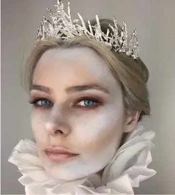 Woman with ice queen costume and white and gray face makeup