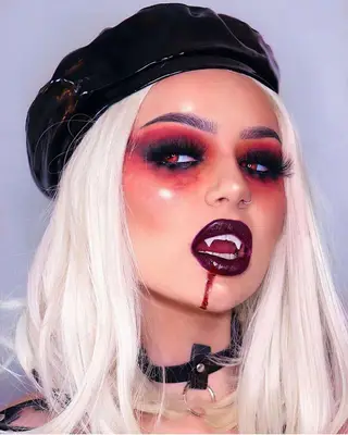 woman in blood dripping red vampire makeup and leather beret