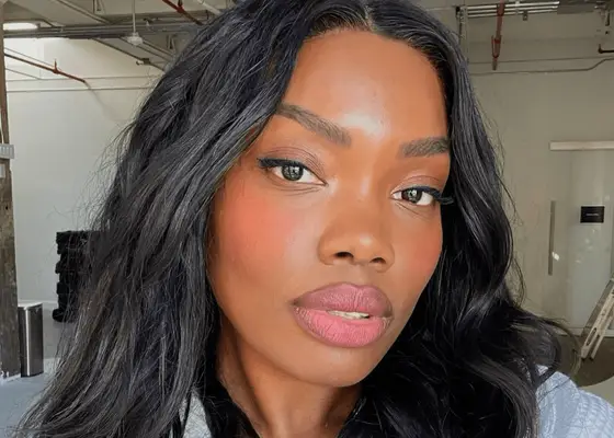 Model with long black hair and bright pink blush 