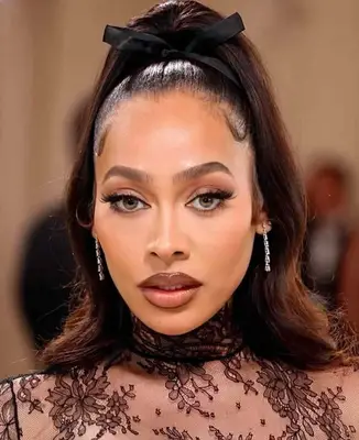 Lala wears a thick winged eyeliner with brown lipstick and shaped eyebrows