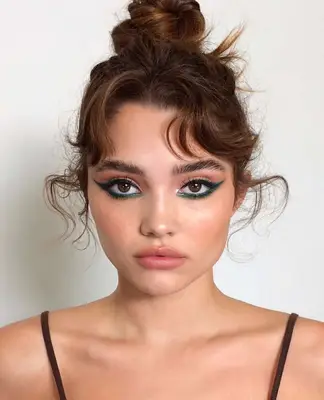 model wears emerald green winged eyeliner 