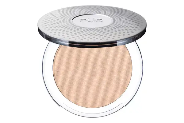 Close up of a person using a makeup sponge to blend skin tint on their face