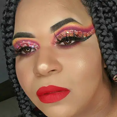 Makeup artist with sparkly burgundy and gold dramatic eye makeup and red lipstick