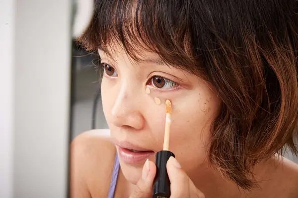 A person applying the NYX Professional Makeup Can