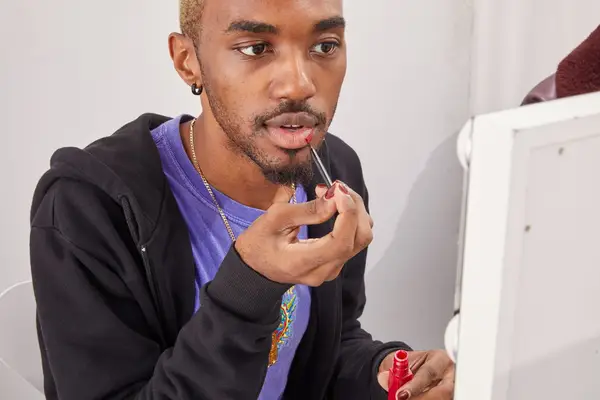 A person applying Maybelline SuperStay Matte Ink Liquid Lipstick on their lips