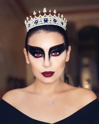 Makeup artist with Black Swan-inspired look, red contacts, and tiara