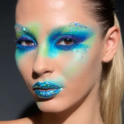 Blue and green sparkling eye makeup with glittering blue lips