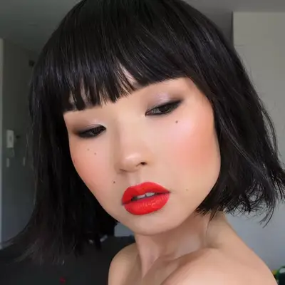 Woman wearing Subtle frosted shadow eye with a bold red lip.