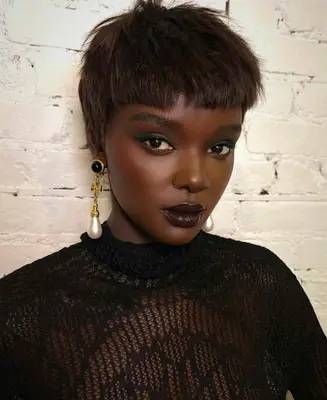 model wears deep berry plum lipstick and dark eyeshadow