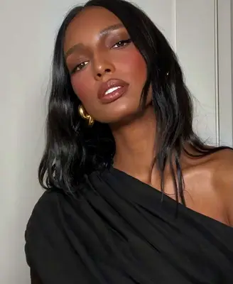 Jasmine Tookes wears a monochromatic berry toned makeup look