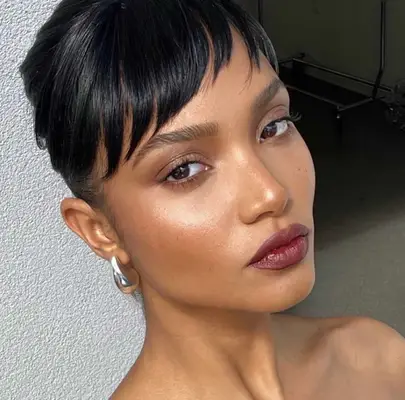 model wears soft taupe eyeshadow and berry stained lipstick